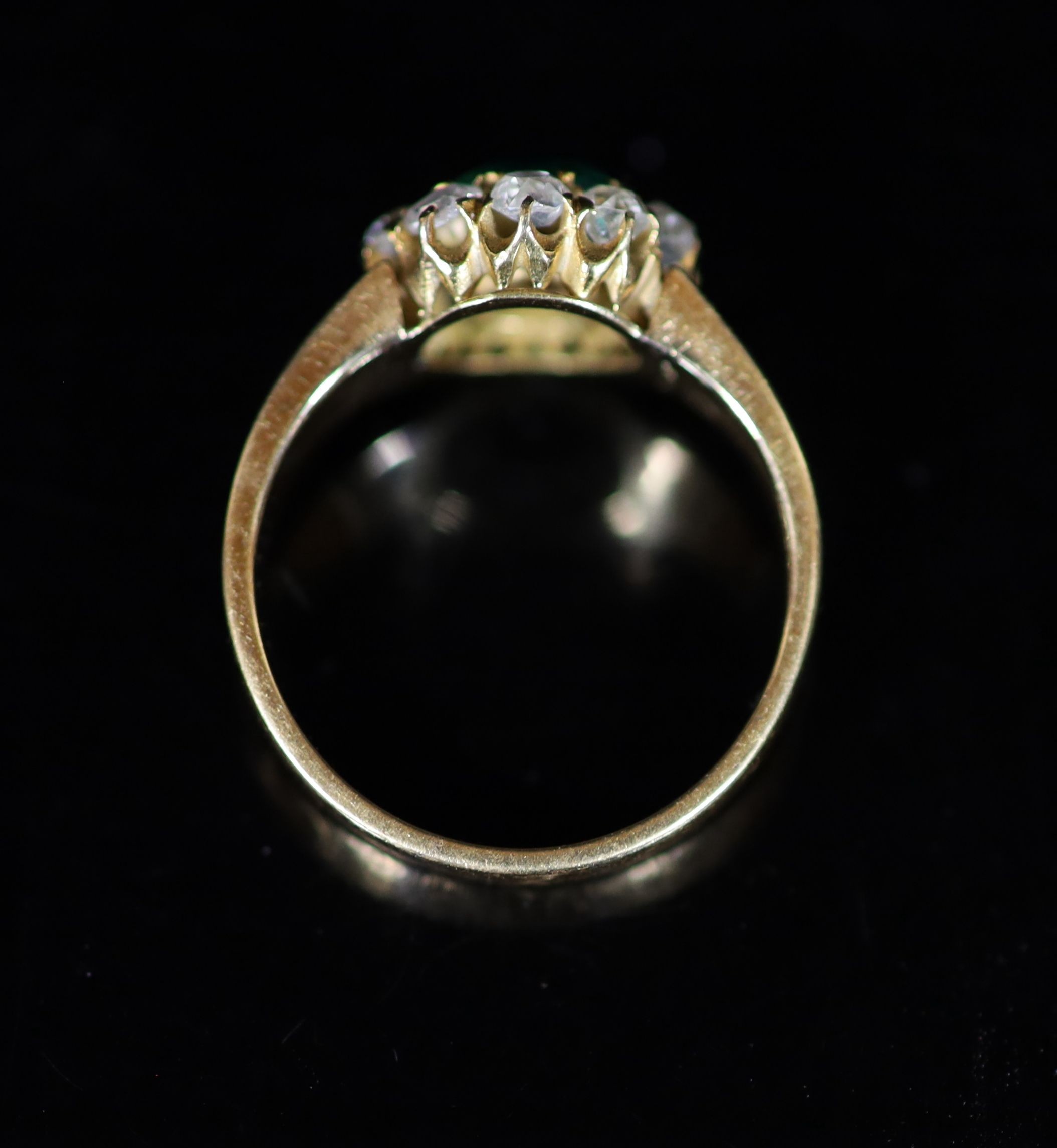 A gold, emerald and old cut diamond set circular cluster ring